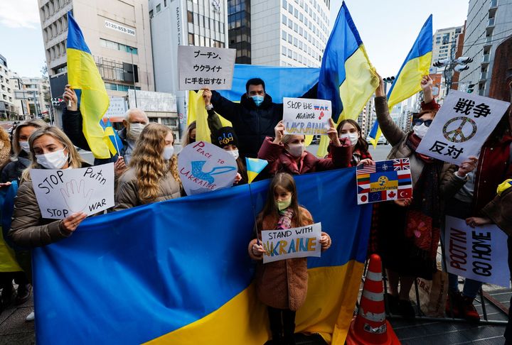 Ουκρανοί που κατοικούν στην Ιαπωνία κρατούν πλακάτ και σημαίες κατά τη διάρκεια συγκέντρωσης διαμαρτυρίας που καταγγέλλουν τη Ρωσία για τις ενέργειές της στην Ουκρανία, κοντά στη ρωσική πρεσβεία στο Τόκιο, Ιαπωνία, 23 Φεβρουαρίου 2022. REUTERS/Issei Kato