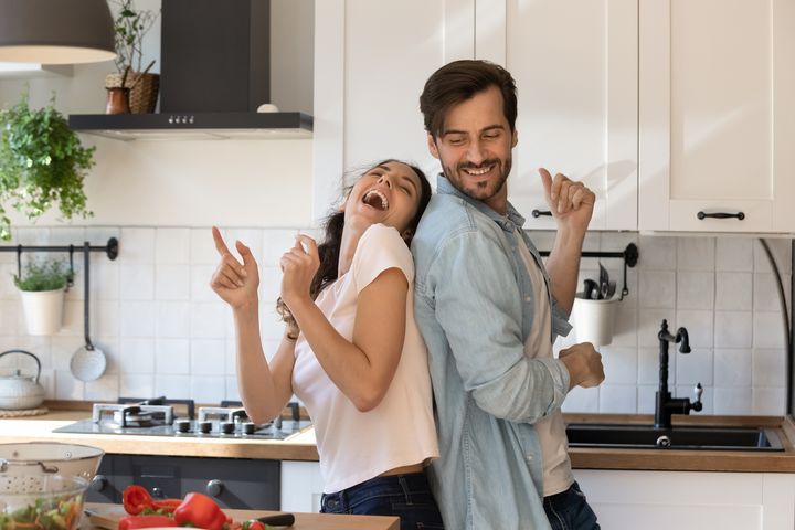 Una pareja bailando feliz en su cocina.