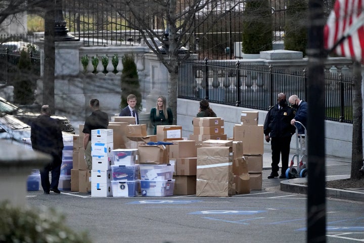 People wait for a moving van after boxes were moved out of the Eisenhower Executive Office building inside the White House complex, on Jan. 14, 2021, in Washington.