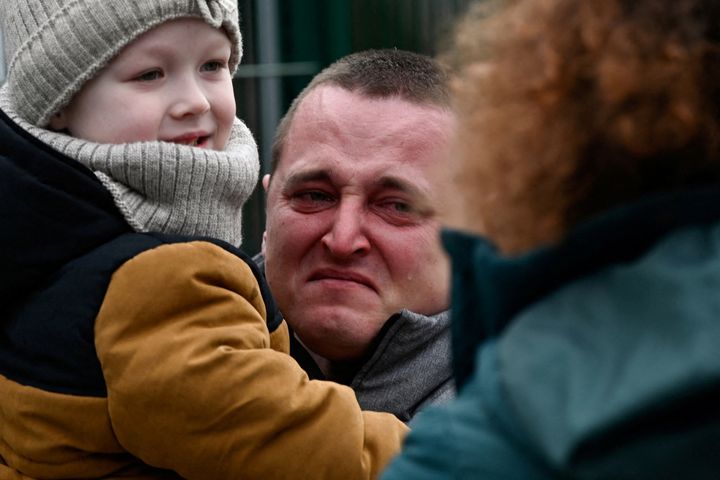 Ένας άντρας που κρατά ένα παιδί ξεσπάει σε κλάματα καθώς φτάνουν από την Ουκρανία στη Σλοβακία