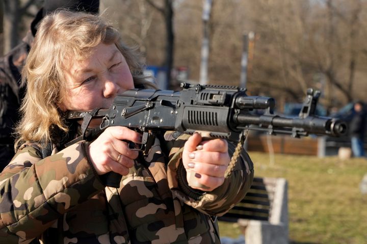 A woman practices using a Kalashnikov assault rifle as members of a Ukrainian far-right group train, in Kyiv, Ukraine, Sunday, Feb. 13, 2022. Russia denies it intends to invade but has massed well over 100,000 troops near the Ukrainian border and has sent troops to exercises in neighboring Belarus, encircling Ukraine on three sides. U.S. officials say Russia's buildup of firepower has reached the point where it could invade on short notice. (AP Photo/Efrem Lukatsky)