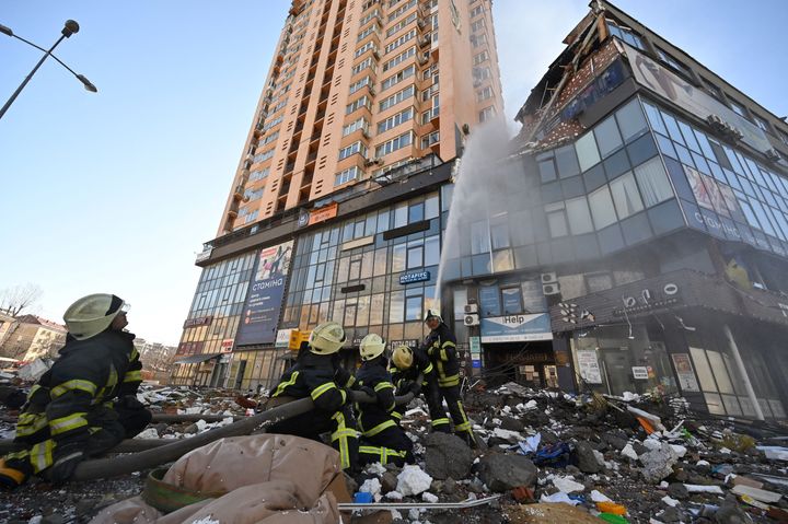 2022年2月26日撮影、キエフでミサイル攻撃を受けたと思われる高層アパートで消防士が消火活動を行っている。(Photo by GENYA SAVILOV/AFP via Getty Images)