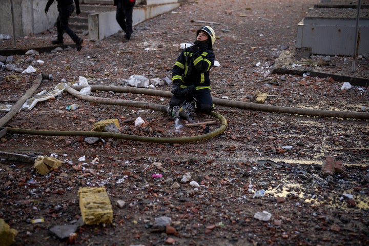 A firefighter works near an apartment building damaged by a rocket attack in Kyiv on Saturday.