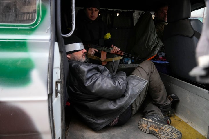 Ukrainian troops escort a man who they suspect is a Russian agent in Kyiv, Ukraine, Sunday, Feb. 27, 2022. Ukrainian authorities say that Russian troops have entered Ukraine's second-largest city of Kharkiv and fighting is underway in the streets. (AP Photo/Efrem Lukatsky)