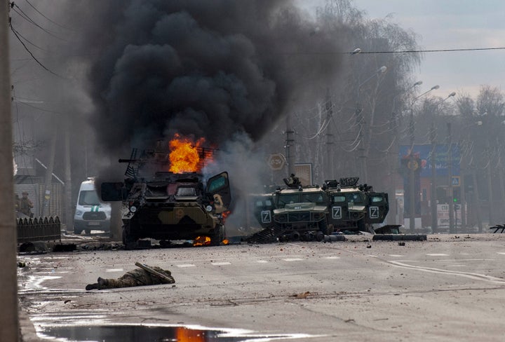 An armored personnel carrier burns and damaged light utility vehicles stand abandoned after fighting in Kharkiv, Ukraine, Sunday, Feb. 27, 2022. The city authorities said that Ukrainian forces engaged in fighting with Russian troops that entered the country's second-largest city on Sunday. (AP Photo/Marienko Andrew)