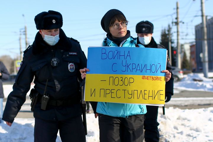 Police detain a demonstrator with a poster reading "The war with Ukraine is a shame and a crime" in Omsk, Russia, on Sunday.