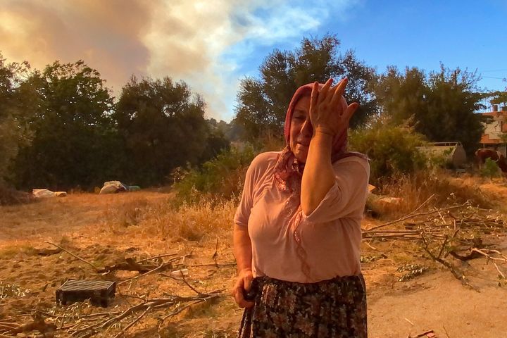 A woman cries during a massive forest fire that engulfed a Mediterranean resort region on Turkey's southern coast, near the town of Manavgat, on July 29, 2021.