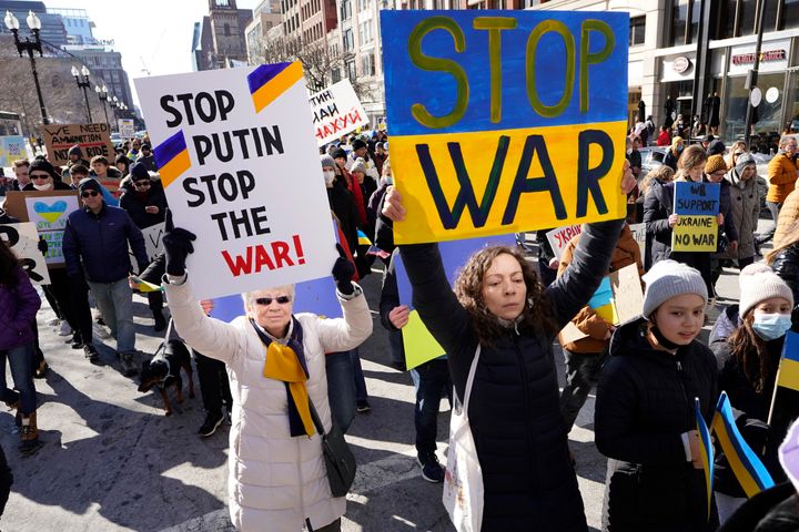 Demonstrators display placards as they march during a rally in support of Ukraine, Sunday, Feb. 27, 2022, in Boston. (AP Photo/Steven Senne)