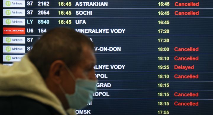 A man walks past a departures display board at the Moscow Domodedovo International Airport in Russia on Thursday after flight services to a number of airports in the South of Russia were temporarily restricted amid heightened tensions in Ukraine.