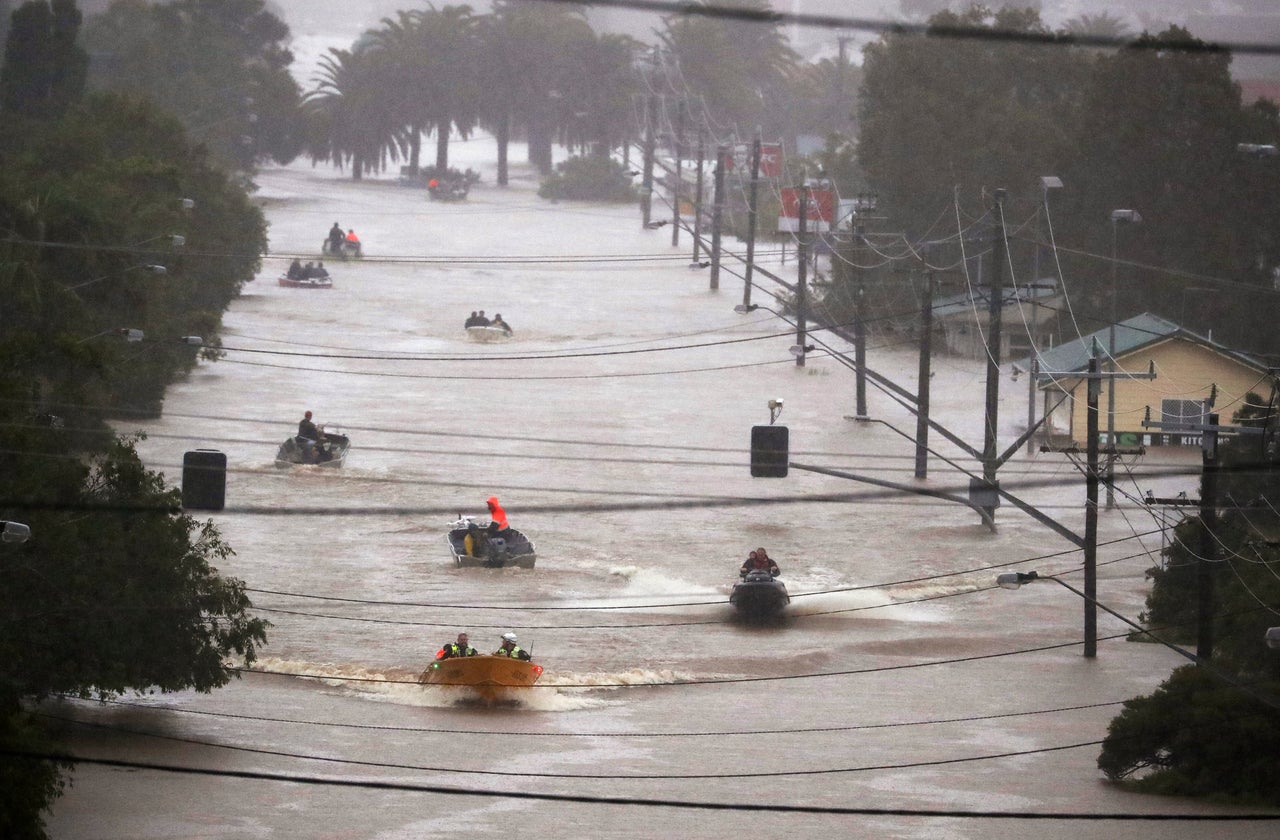 People use small boats to travel through flood water in Lismore, Australia on Monday.