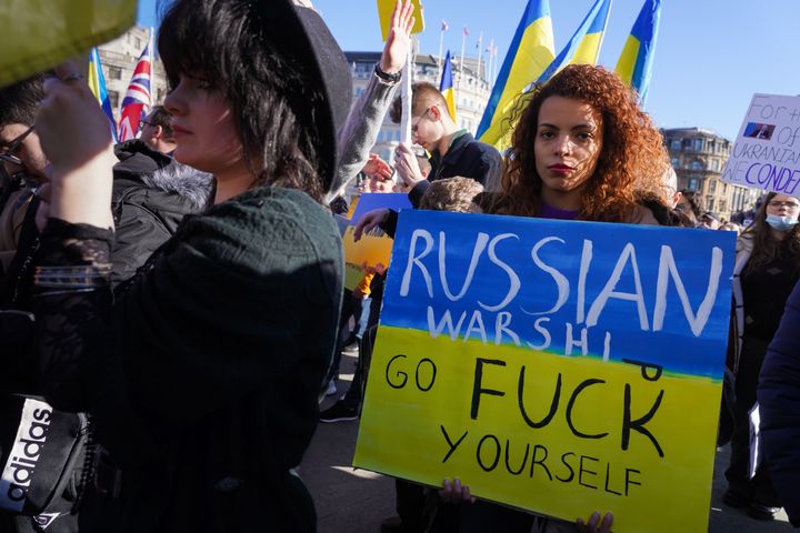 A protester in London holds a placard bearing the same message Ukrainian soldiers on Snake Island sent to the Russians when asked to surrender.