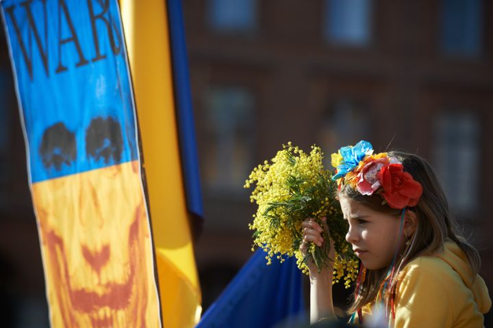 フランス・トゥールーズで開かれたロシア軍のウクライナ侵攻に反対するデモで、ミモザの花束を手にする若者（2022年2月27日）