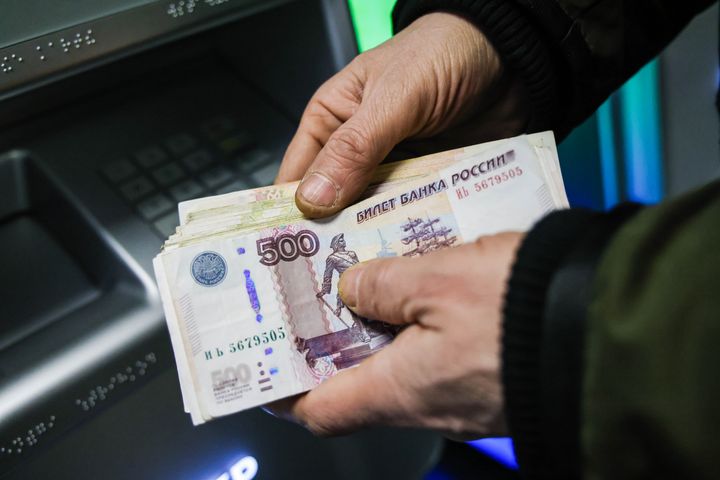 A person holds cash withdrawn from an ATM at a Sberbank branch in Moscow on Feb. 28.