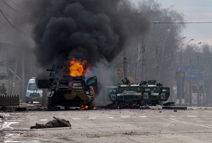 An armored personnel carrier burns and damaged light utility vehicles stand abandoned after fighting in Kharkiv, Ukraine, Sunday, Feb. 27, 2022. The city authorities said that Ukrainian forces engaged in fighting with Russian troops that entered the country's second-largest city on Sunday. 