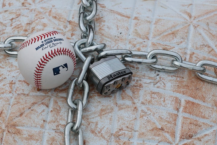 An official MLB baseball sits on top of an MLB game-used base with a lock and chain around it to represent the lockout between Major League Baseball and the Major League Baseball Players Association on Jan. 28, 2022 in Lincroft, New Jersey.
