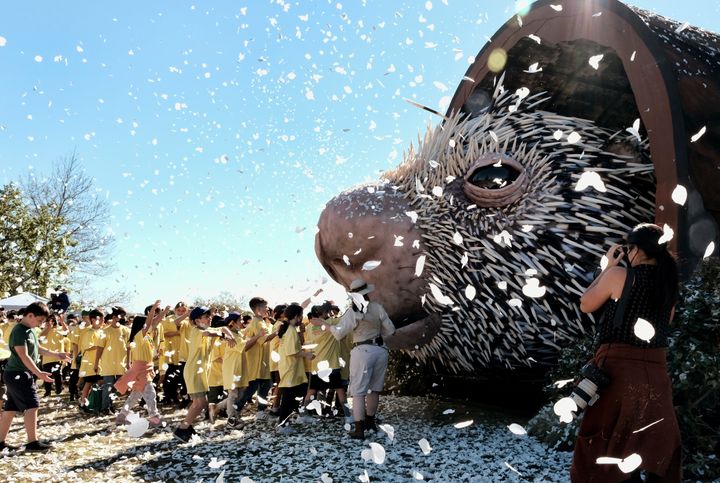 Los Angeles school children run to see a giant puppet porcupine named Percy at Elysian Park in Los Angeles on Tuesday, March 1, 2022. (AP Photo/Richard Vogel)