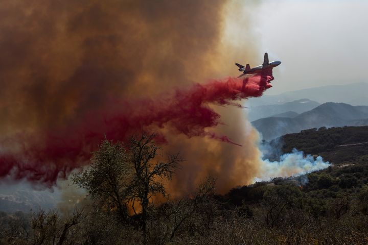A firefighting jet drops fire retardant as the Alisal Fire burns on Oct. 13, 2021, near Goleta, California.