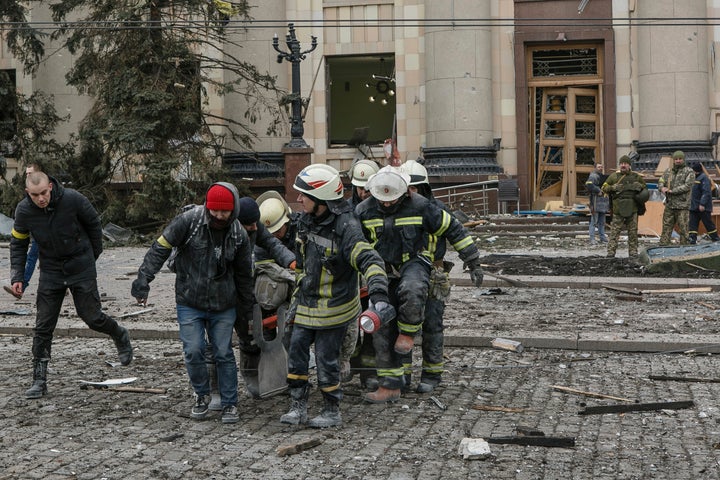 Emergency service personnel carry the body of a victim out of the damaged City Hall building following shelling in Kharkiv, Ukraine on Tuesday.
