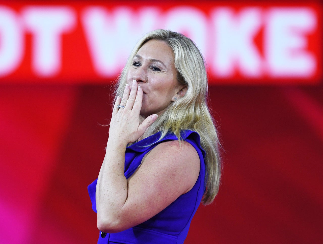 Greene blows kisses to the crowd before speaking at CPAC. Hours earlier she had spoken at a white nationalist conference.