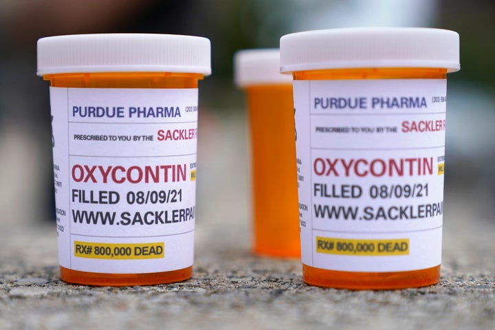 FILE - In this Aug. 9, 2021, file photo, fake pill bottles with messages about OxyContin maker Purdue Pharma are displayed during a protest outside the courthouse where the bankruptcy of the company is taking place in White Plains, N.Y. A federal judge should reject a sweeping settlement to thousands of lawsuits against OxyContin maker Purdue Pharma, a group of states said at a hearing Tuesday, Nov. 30, 2021 arguing that the protections it extends to members of the Sackler family who own the firm are improper. (AP Photo/Seth Wenig, File)