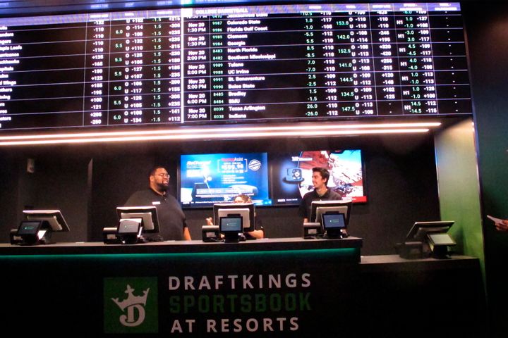 FILE - Employees work at the DraftKings sportsbook at Resorts Casino in Atlantic City N.J., in Nov. 20, 2018. In an action made public on Wednesday, March 2, 2022, New Jersey gambling regulators fined DraftKings $150,000 for allowing a Florida man to make online bets from his home by using a friend in New Jersey to place them for him, in violation of New Jersey's ban on proxy betting. (AP Photo/Wayne Parry, File)