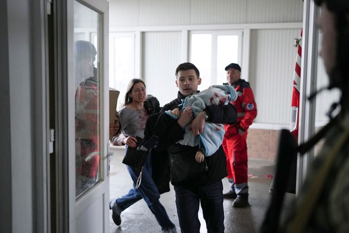 H Μαρίνα Γιάτσκο τρέχει πίσω από τον σύντροφό της Φεντόρ, που κρατά στα χέρια το 18 μηνών μωρό τους που τραυματίστηκε θανάσιμα κατά τη διάρκεια βομβαρδισμού την Μαριούπολη (4 Μαρτίου 2022)
