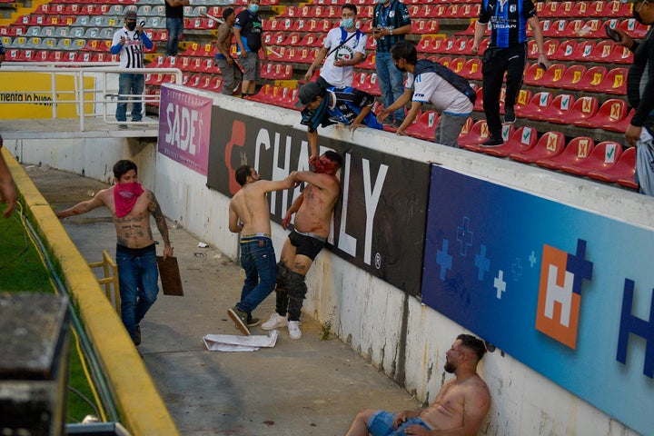 Fans clash during a Mexican soccer league match between the host Querétaro and Atlas from Guadalajara, at the Corregidora stadium, in Querétaro, Mexico, Saturday, March 5, 2022. Multiple people were injured during the brawl, including two critically.