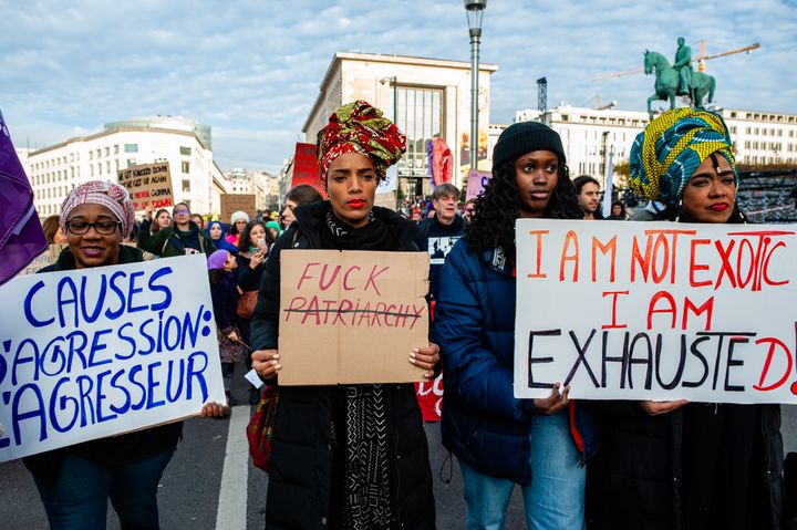 Tres mujeres negras con mensajes feministas y antirracistas en una manifestación en Bruselas (Bélgica).