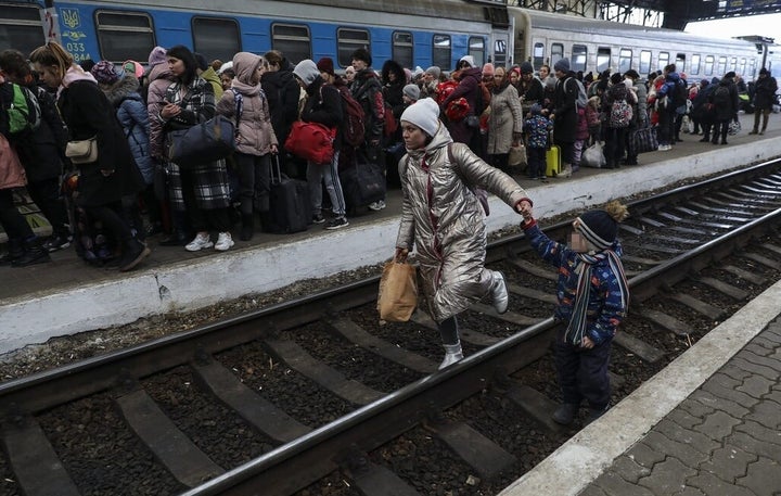 Una mujer camina con su hijo por las vías del tren en la estación de Lviv.