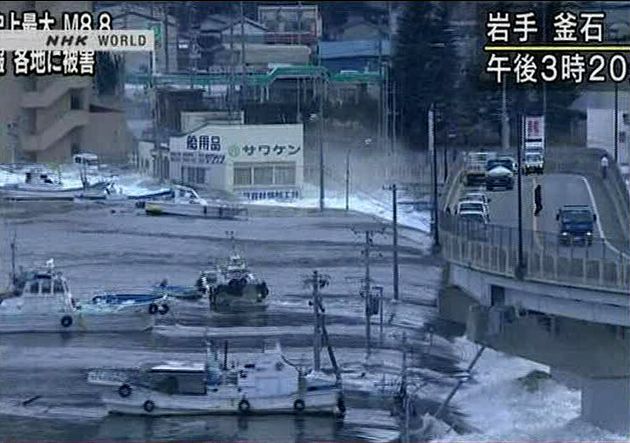 2011年3月11日、岩手県釜石市で発生した地震による津波がボートを押し流す様子（NHKテレビ）