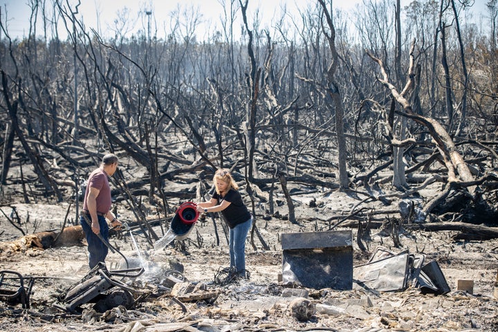 Hector Rivera and Wandi Blanco put water on hotspots behind their home in Panama City on Saturday.