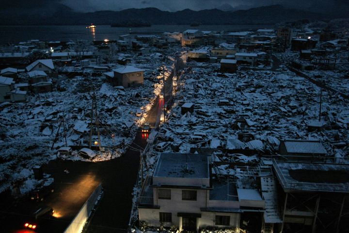 東日本大震災で津波被害を受けた岩手県山田町。停電の中で通行する車のヘッドライトだけが明るい（2011年3月16日撮影）