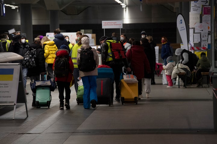 Refugees from the Ukrainian war zone walk to a collection point at a train station in Berlin.