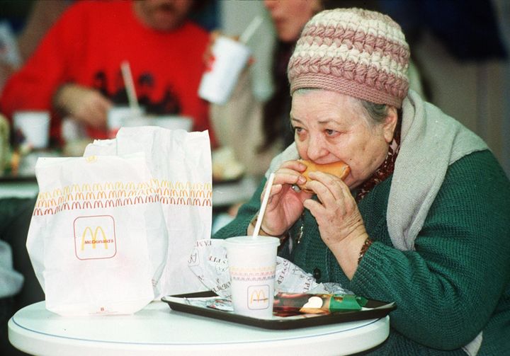 ソビエト連邦初のマクドナルドの開店日に、ハンバーガーを食べる年配の女性（1990年1月31日撮影）