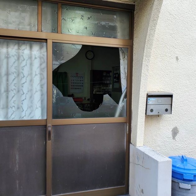 割れて大きく穴の開いた「在日本大韓民国民団」枚岡支部の事務所の窓ガラス