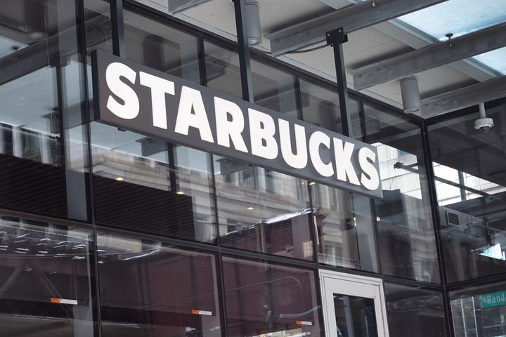 A Starbucks sign hangs above the entrance of one of the chain's coffee shops in the Loop in January in Chicago. Workers at three more Starbucks stores in western New York have voted to unionize.