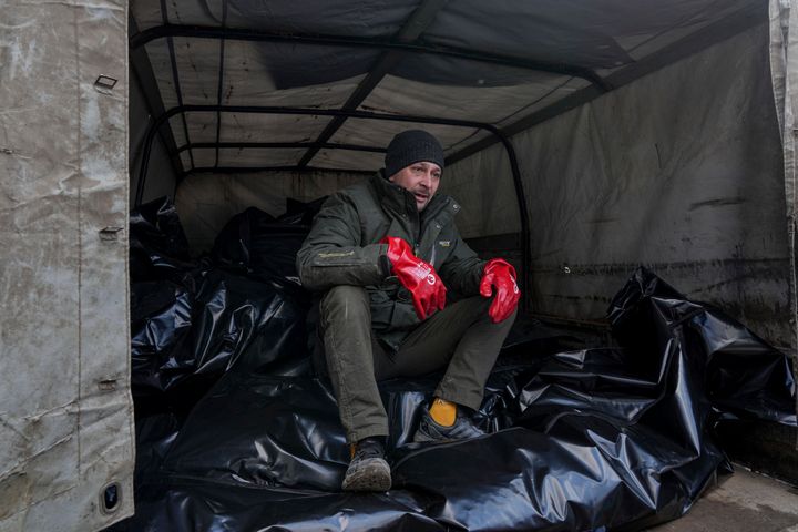 Ένας εργάτης νεκροτομείου κάθεται σε σακούλες πτωμάτων προτού μεταφερθούν για να ταφούν σε έναν ομαδικό τάφο στα περίχωρα της Μαριούπολης της Ουκρανίας, Τετάρτη 9 Μαρτίου 2022. (AP Photo/Evgeniy Maloletka)