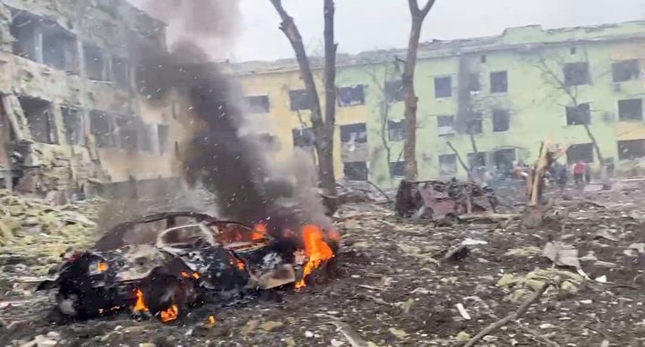 A car burns after the destruction of Mariupol children's hospital as Russia's invasion of Ukraine continues