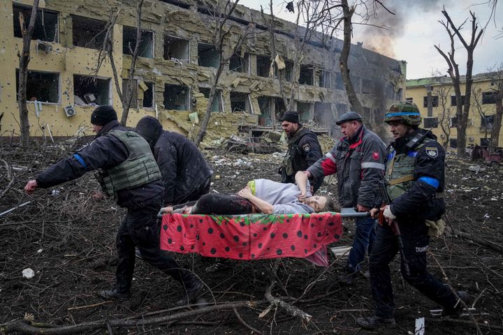 Ukrainian emergency employees and volunteers carry an injured pregnant woman from a maternity hospital that was damaged by shelling in Mariupol, Ukraine, Wednesday, March 9, 2022. (AP Photo/Evgeniy Maloletka)