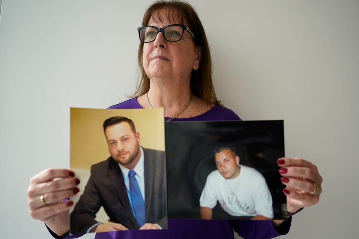 Cheryl Juaire on Thursday poses for a picture with photos of her sons who died from overdoses, Sean Merrill (left) and Corey Merrill.