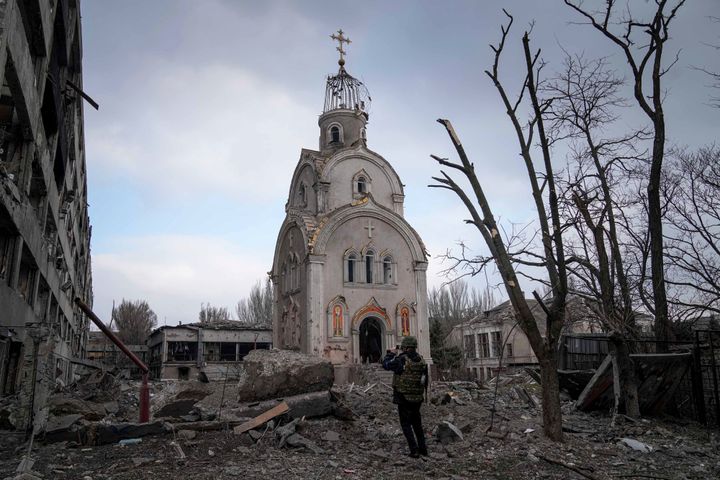 A Ukrainian soldier takes a picture of a church damaged after a shelling in a residential area of ​​Mariupol, Ukraine, Thursday, March 10, 2022. (AP Photo/Evgeniy Maloletka)