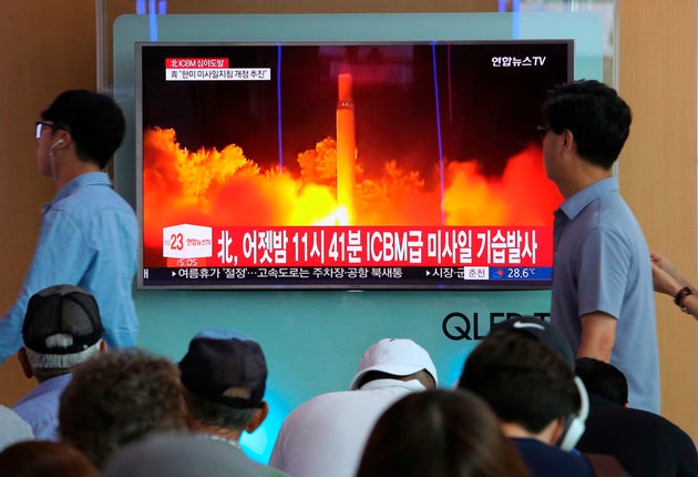 韓国・ソウルで、北朝鮮の大陸間弾道ミサイル(ICBM)の発射実験の映像を流すテレビのニュース番組を見る人々(2017年7月29日撮影)