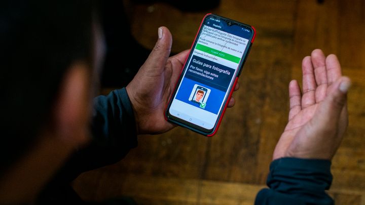 Ecuadorian immigrant Neptali Chiluisa shows the app that he uses for reporting his location to Immigration authorities, during an interview Oct. 21, 2021, in New York. U.S. immigration authorities are turning to smartphones to keep tabs on immigrants and ensure they attend their deportation hearings. 