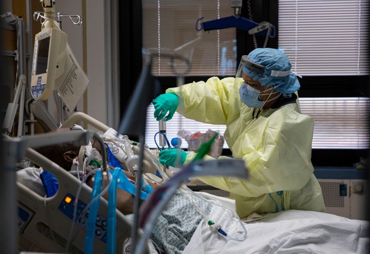 A nurse gives medication to a patient with COVID-19 in the medical intensive care unit at the Veterans Affairs Medical Center on April 24, 2020, in New York City.
