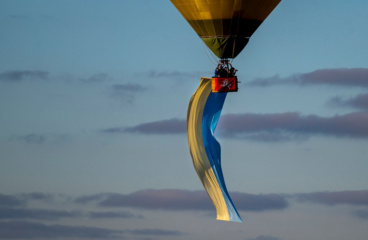 A hot-air balloon decorated with a Ukrainian national flag floats in the air over Vilnius during the protest against the Russian invasion of Ukraine, in Vilnius, Lithuania, on Saturday, March 5, 2022.