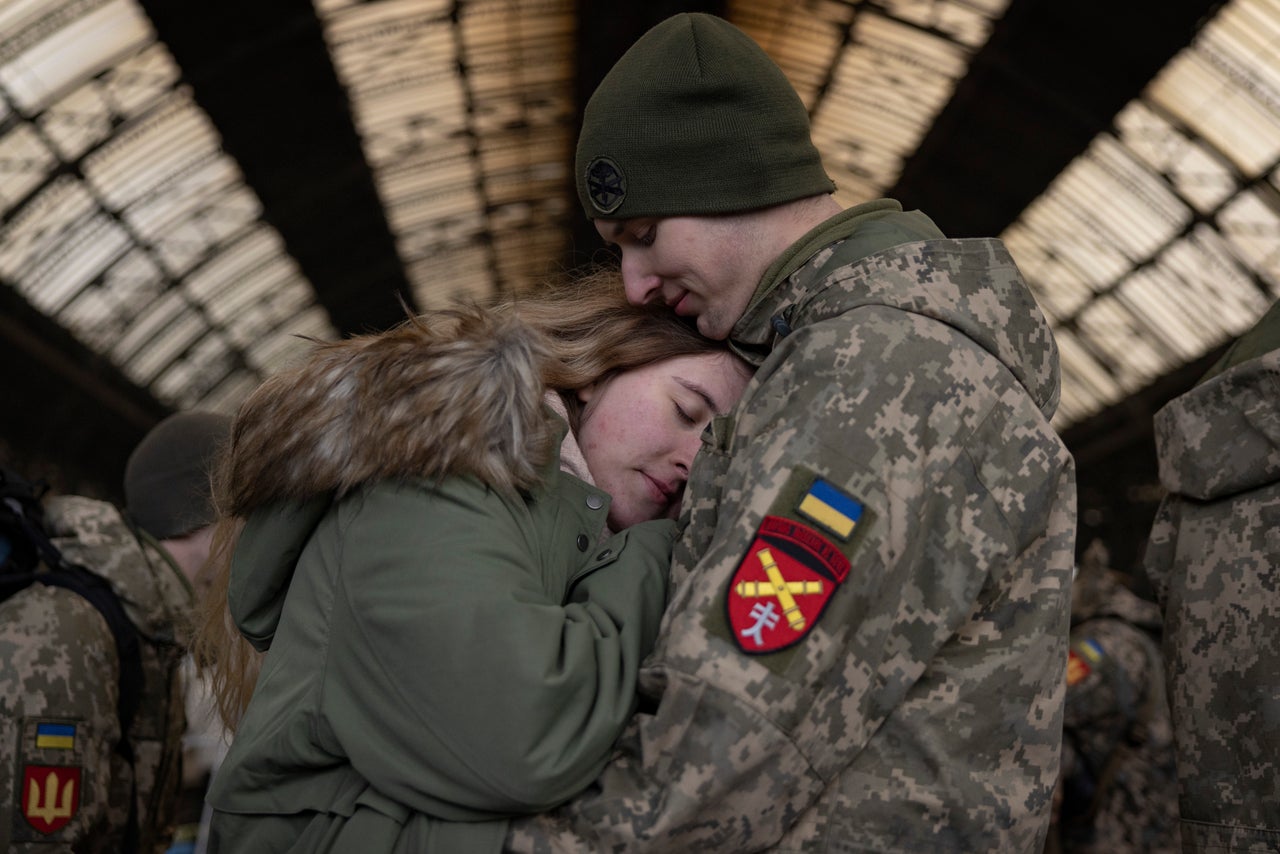 A couple says goodbye from the main train terminal on Wednesday in Lviv, Ukraine. As Ukrainian civilians in the east flee to the relative safety of western cities such as Lviv, and abroad to escape Russia's assault, many military personnel are heading east to help with the war effort.
