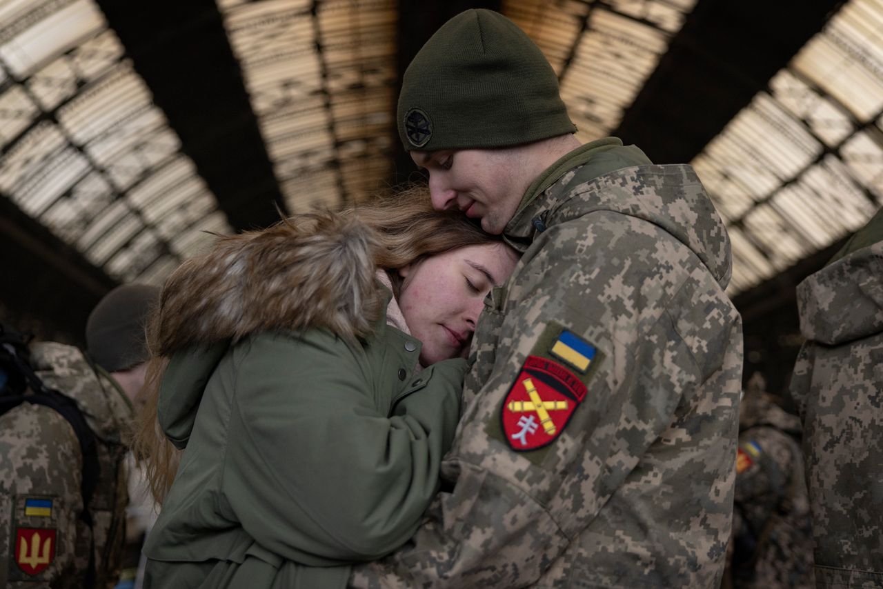 A couple says goodbye from the main train terminal on Wednesday in Lviv, Ukraine. As Ukrainian civilians in the east flee to the relative safety of western cities such as Lviv, and abroad to escape Russia's assault, many military personnel are heading east to help with the war effort.