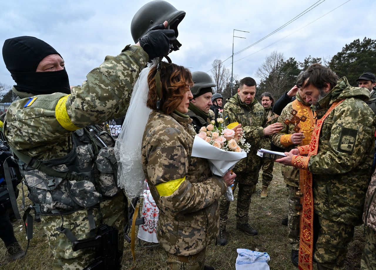 Valery, third from left, and Lesya second from left, both service members of Ukrainian Territorial Defense Forces, get married not far from a checkpoint on the outskirts oof Kyiv on Sunday.