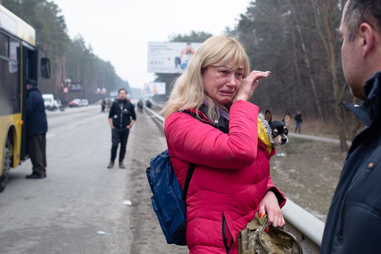 A wife says her goodbyes to her husband, who is a member of the Territorial Defense Forces, as she evacuates from the city on Sunday near Irpin, Ukraine.