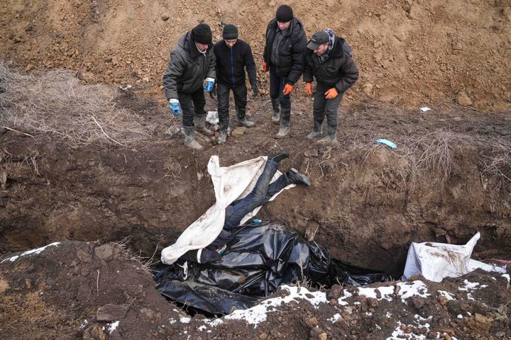 Σώματα νεκρών τοποθετούνται σε ομαδικό τάφο στα περίχωρα της Μαριούπολης, την Τετάρτη 9 Μαρτίου 2022, καθώς η πόλη βομβαρδίζεται σφοδρά από ρωσικές δυνάμεις. (AP Photo/Evgeniy Maloletka)